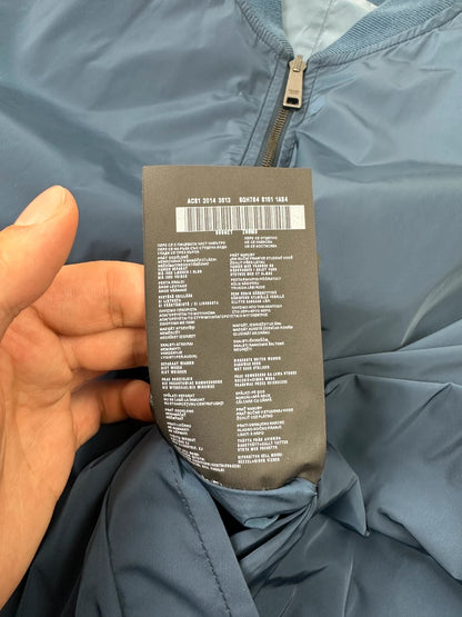 Prada blue reversible bomber jacket, nylon material, featuring logo and sleek minimalist design.