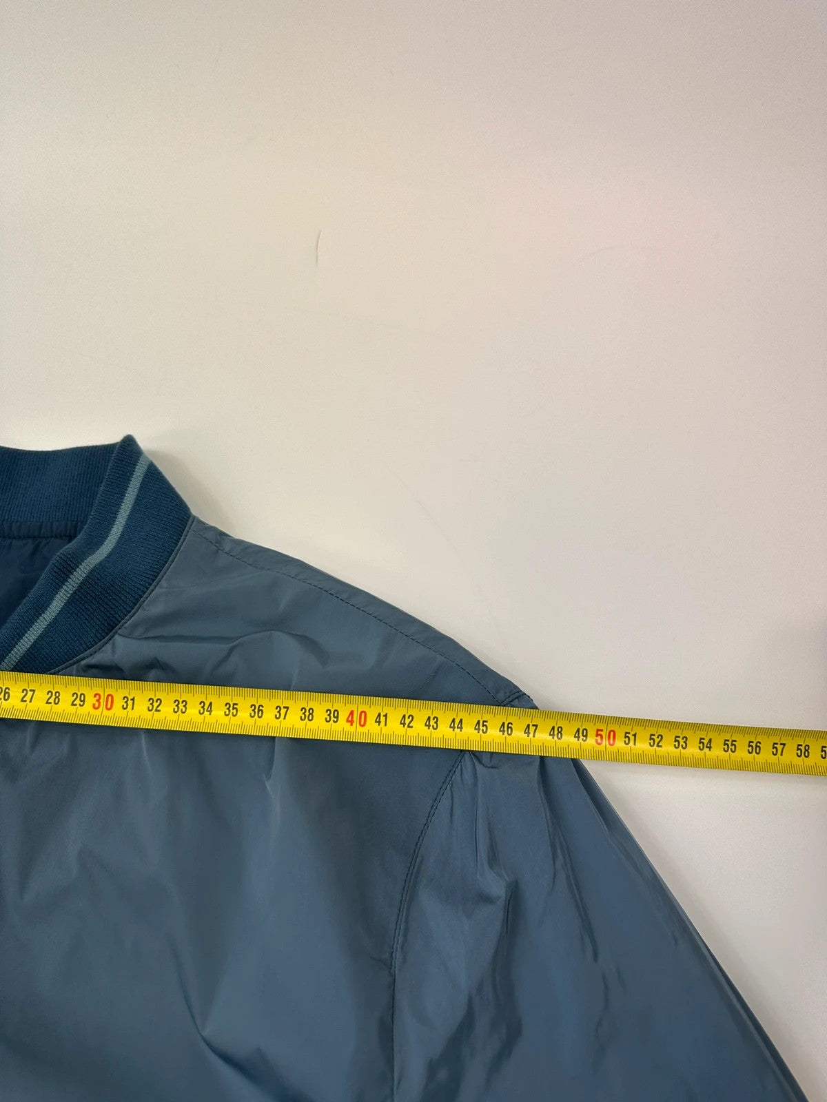 Prada blue reversible bomber jacket, nylon material, featuring logo and sleek minimalist design.