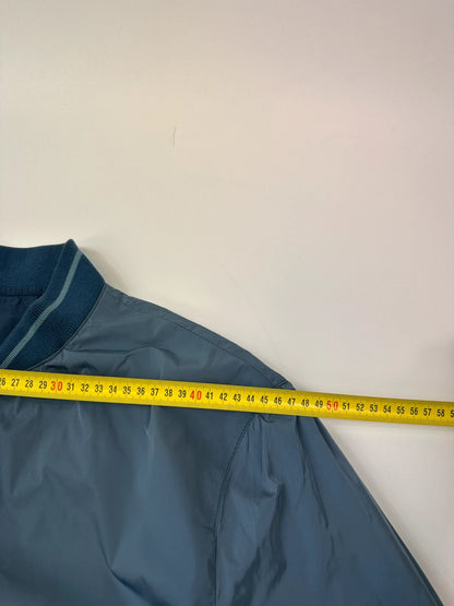 Prada blue reversible bomber jacket, nylon material, featuring logo and sleek minimalist design.
