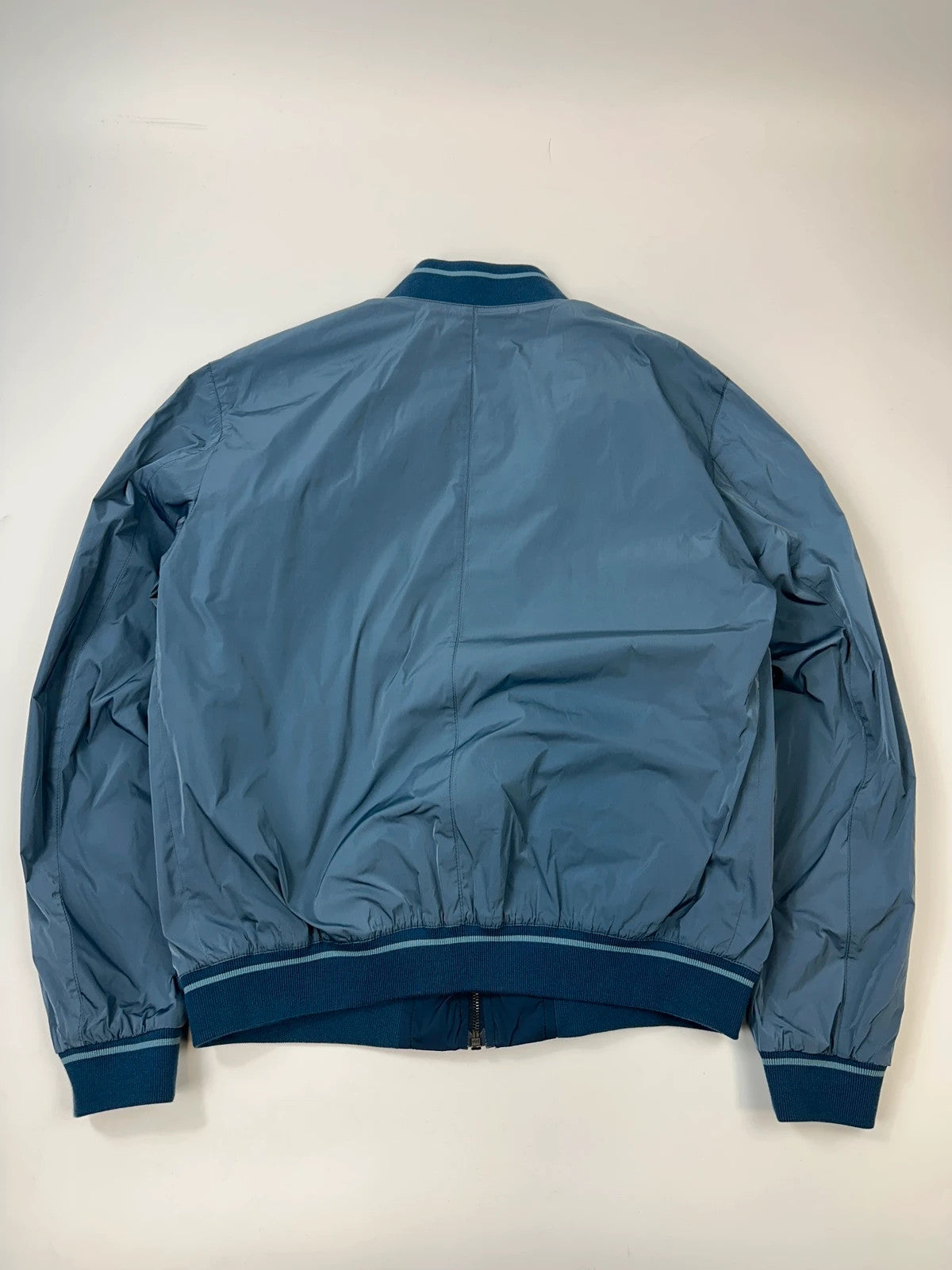Prada blue reversible bomber jacket, nylon material, featuring logo and sleek minimalist design.