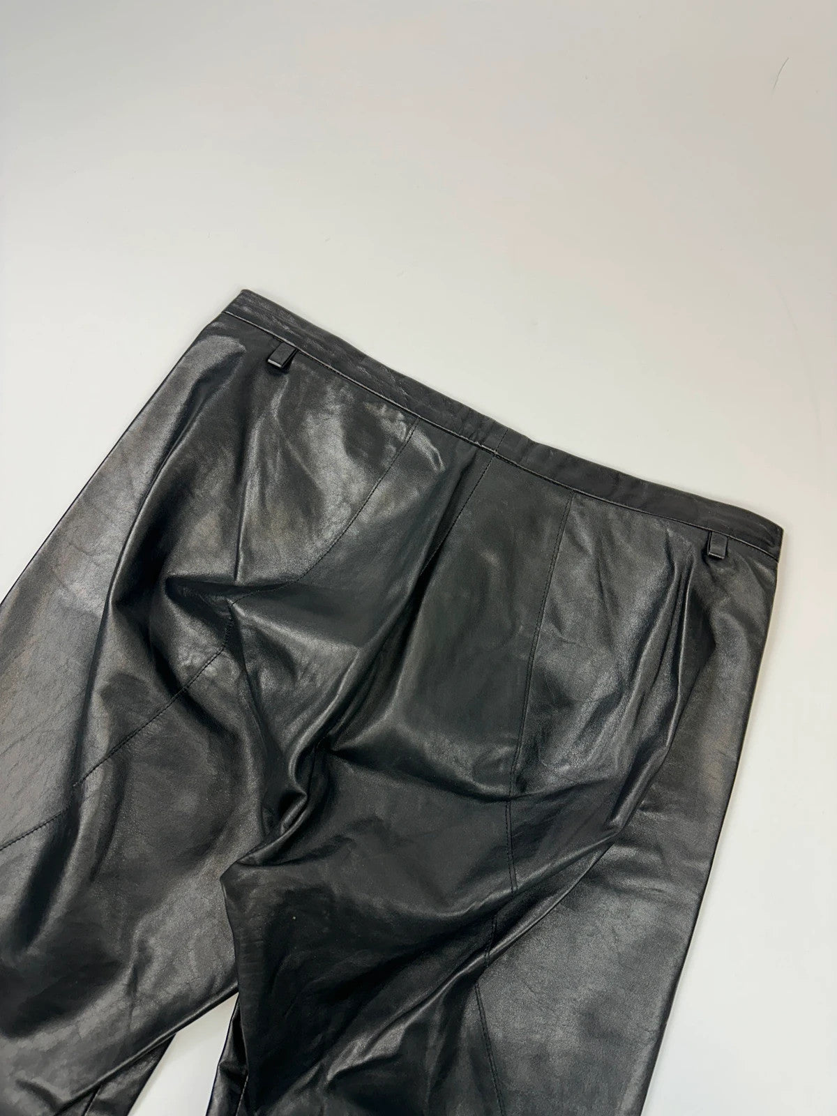 Marithé François Girbaud black flared leather-look trousers with soft texture and vintage design.