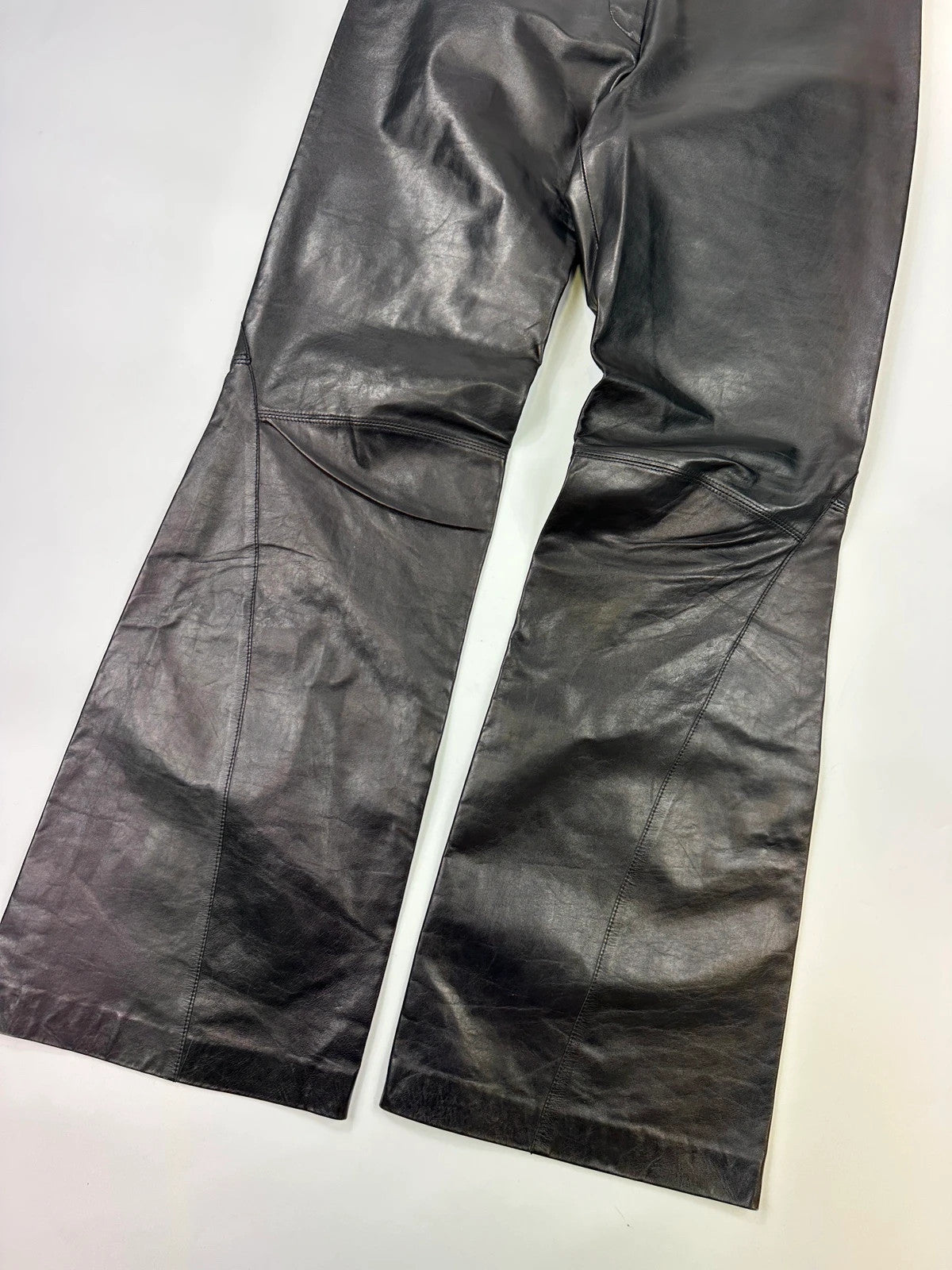 Marithé François Girbaud black flared leather-look trousers with soft texture and vintage design.