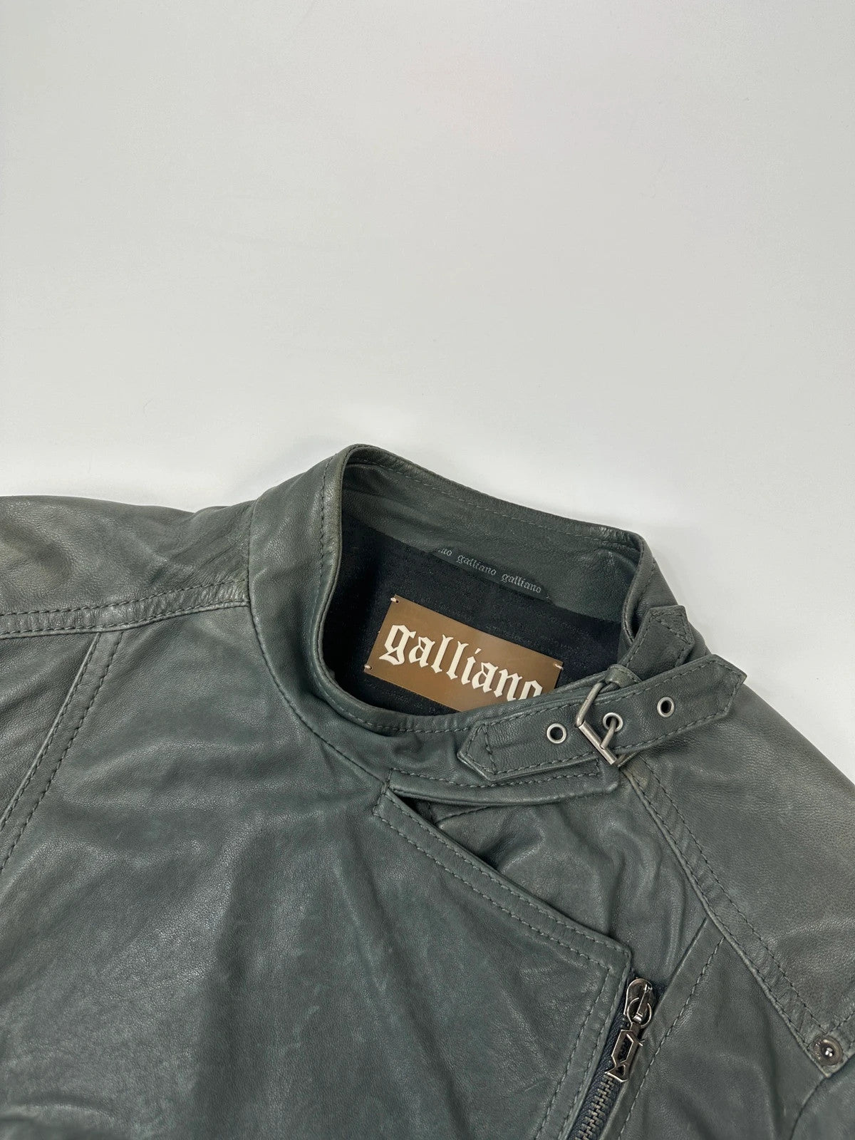 John Galliano khaki green leather jacket with side zip and soft texture.