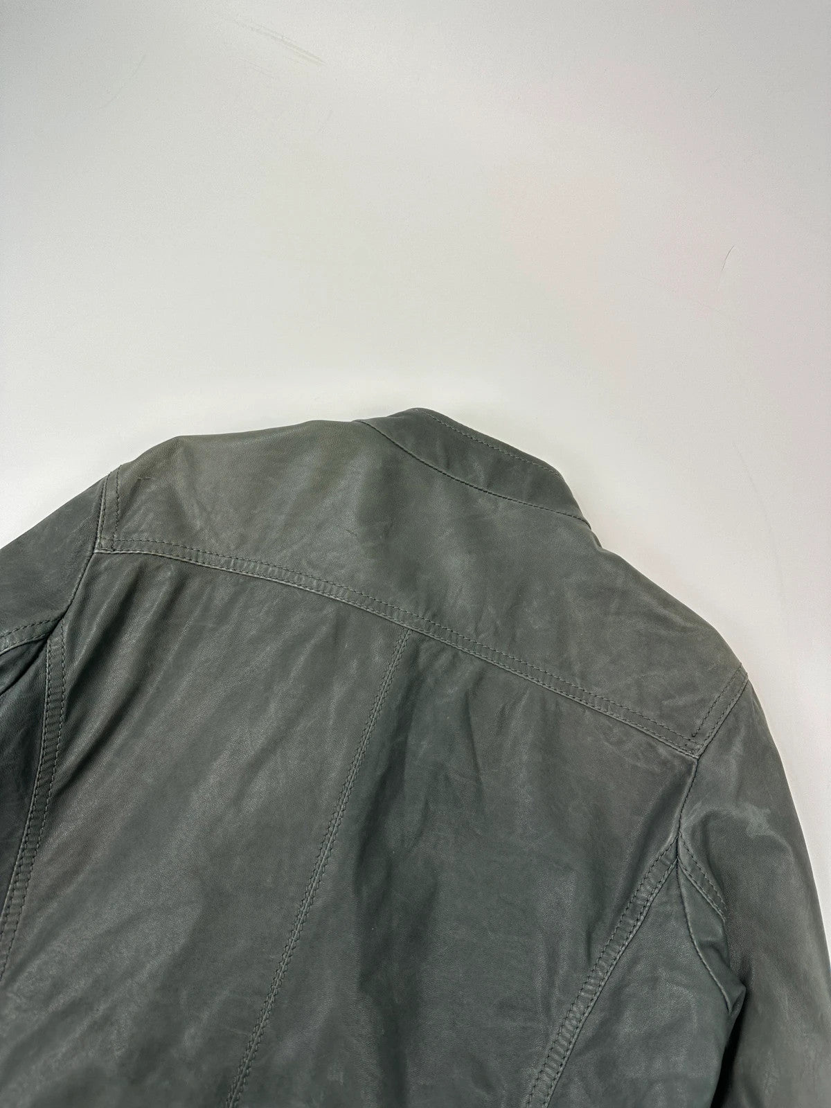 John Galliano khaki green leather jacket with side zip and soft texture.
