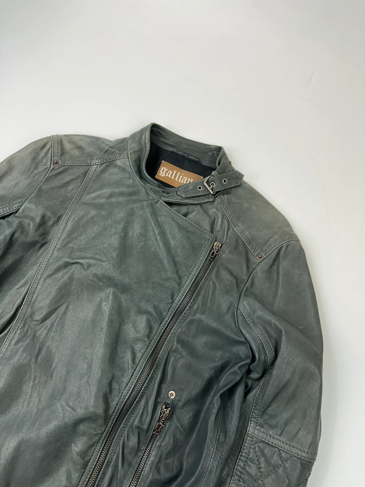 John Galliano khaki green leather jacket with side zip and soft texture.