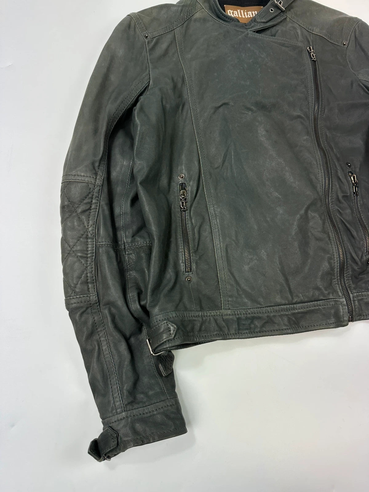 John Galliano khaki green leather jacket with side zip and soft texture.