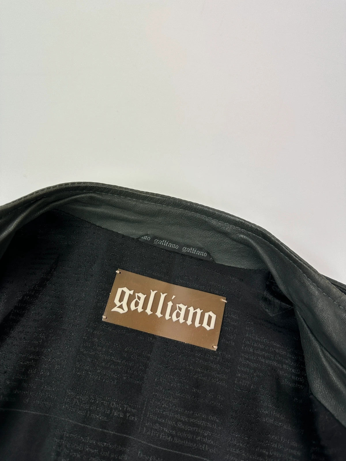 John Galliano khaki green leather jacket with side zip and soft texture.
