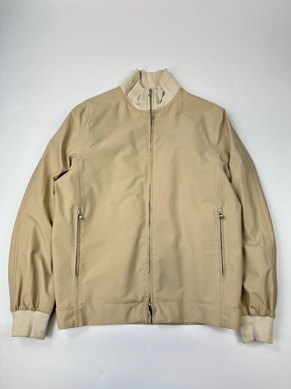 Prada beige Gore-Tex nylon jacket with logo detail and minimalist design.