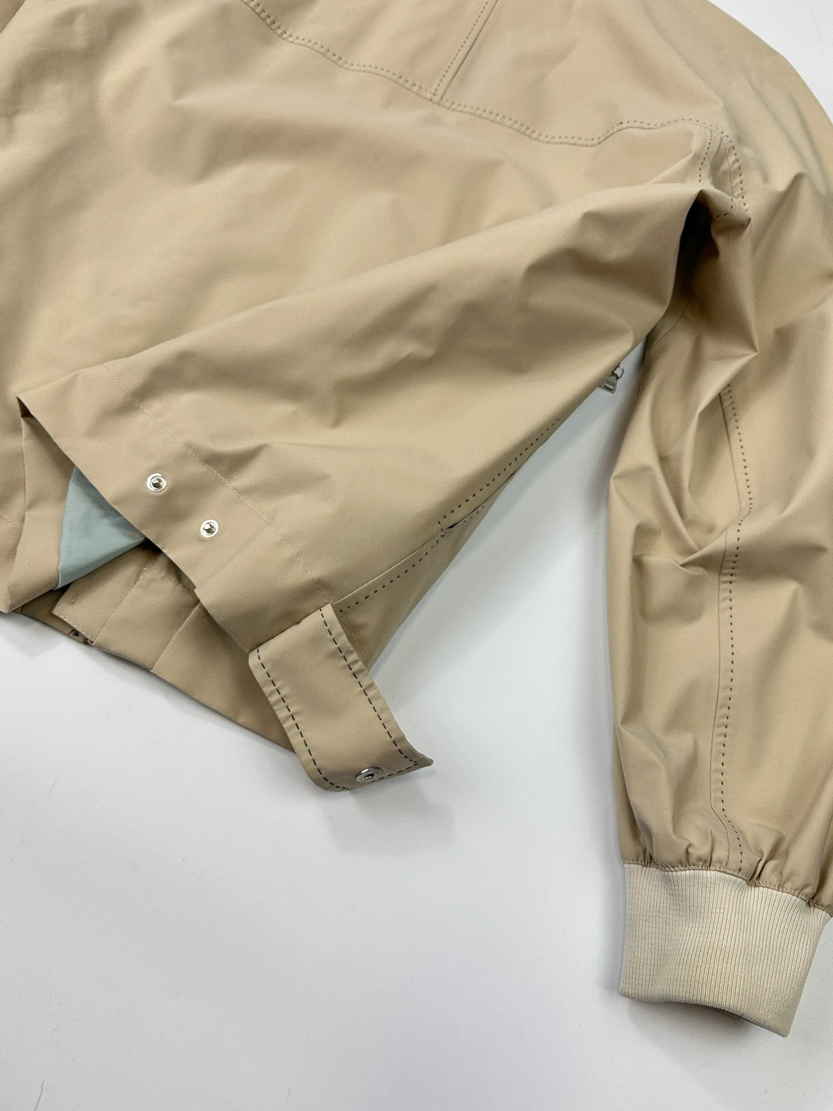Prada beige Gore-Tex nylon jacket with logo detail and minimalist design.