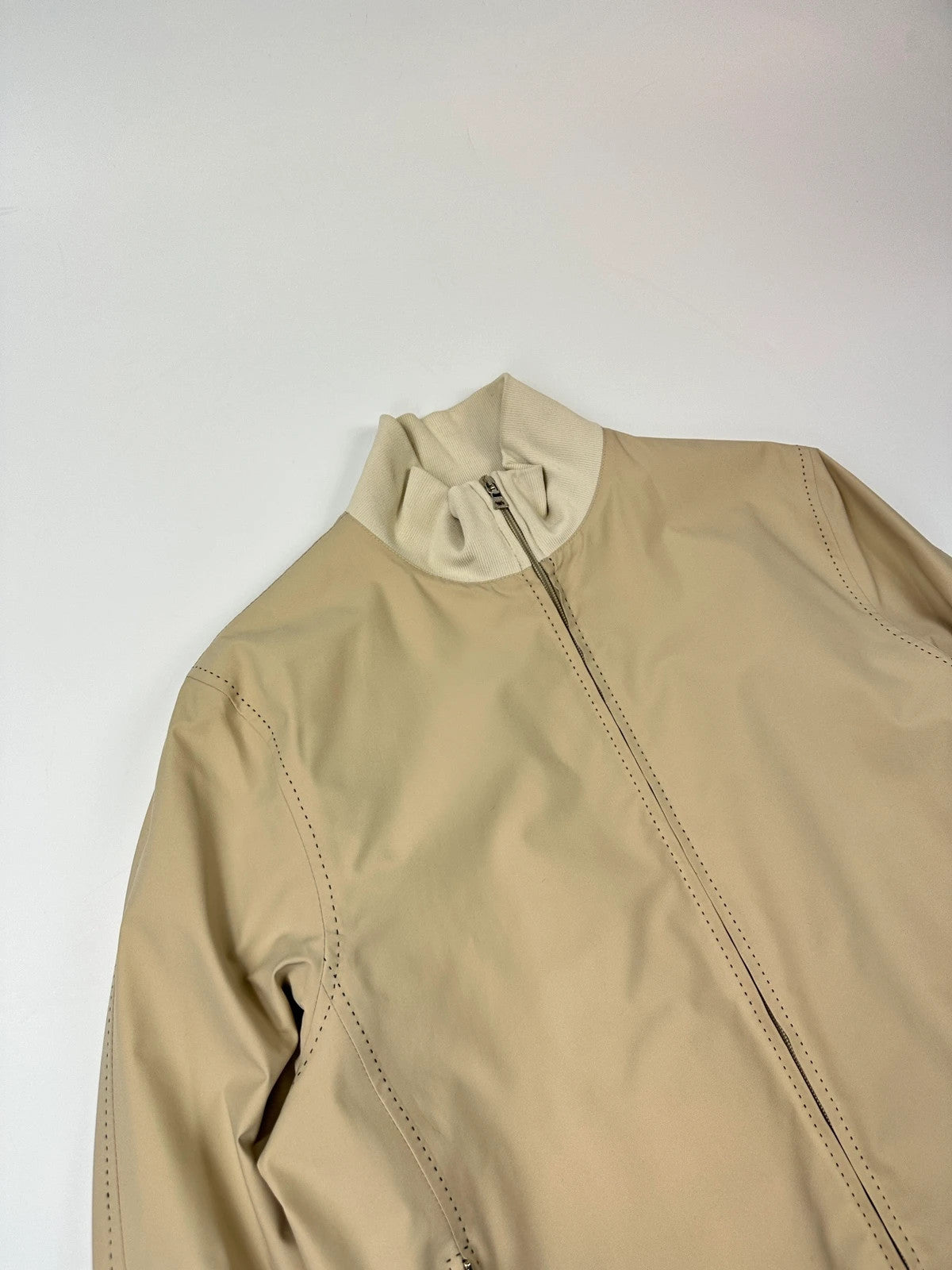 Prada beige Gore-Tex nylon jacket with logo detail and minimalist design.