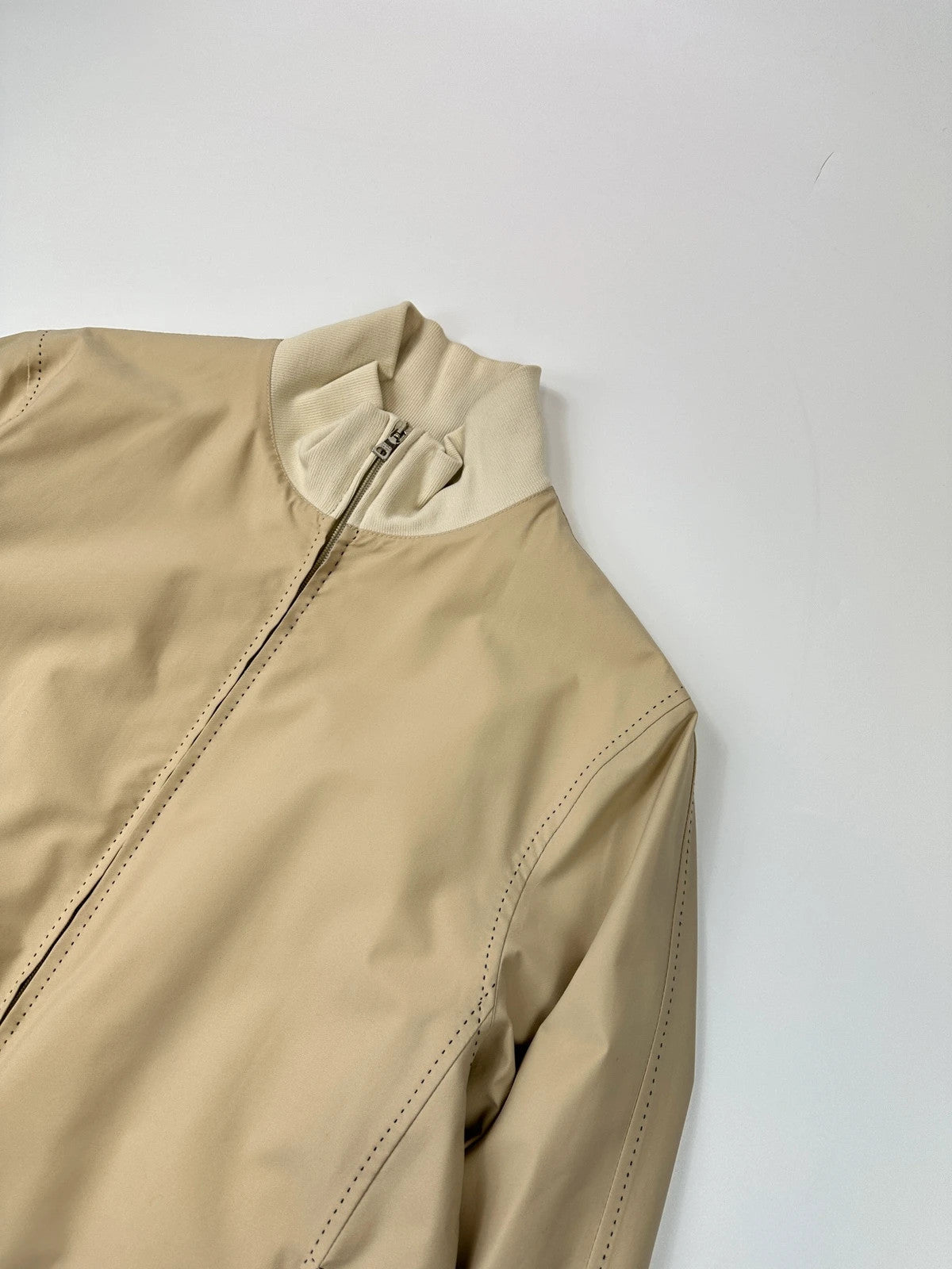 Prada beige Gore-Tex nylon jacket with logo detail and minimalist design.