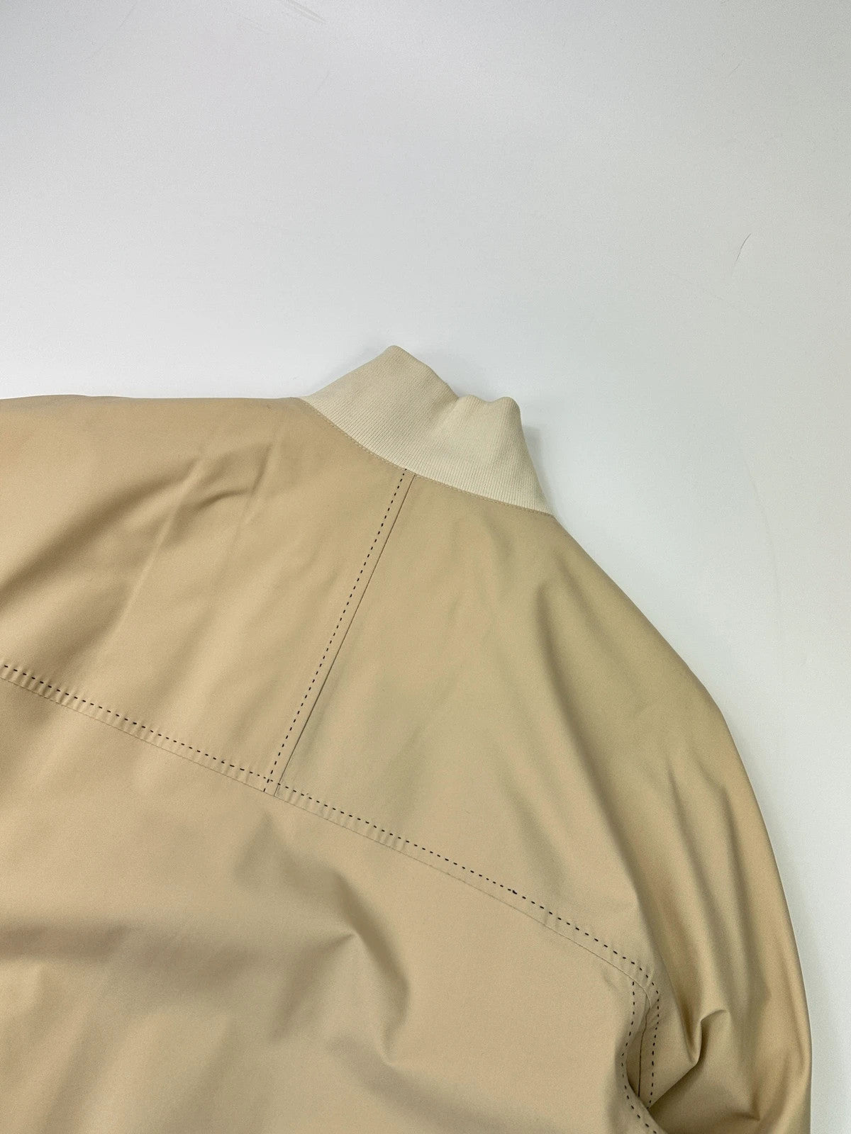 Prada beige Gore-Tex nylon jacket with logo detail and minimalist design.