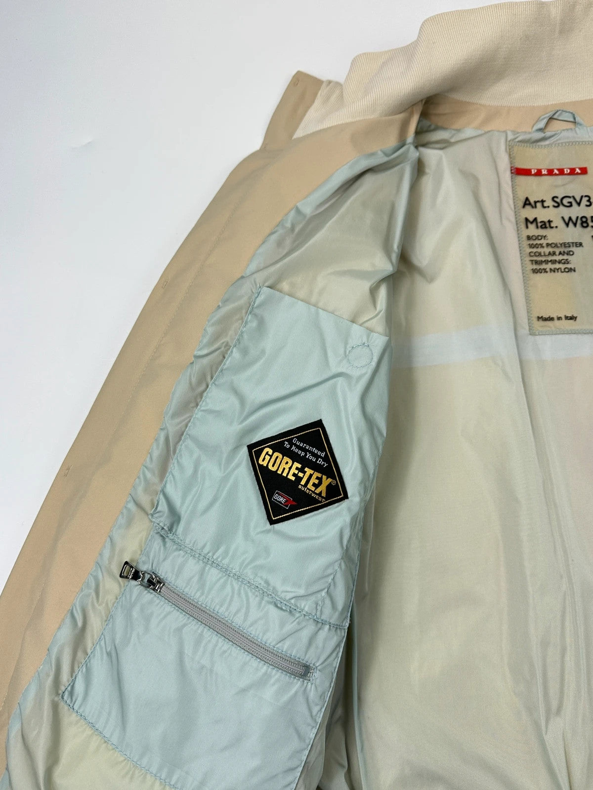 Prada beige Gore-Tex nylon jacket with logo detail and minimalist design.