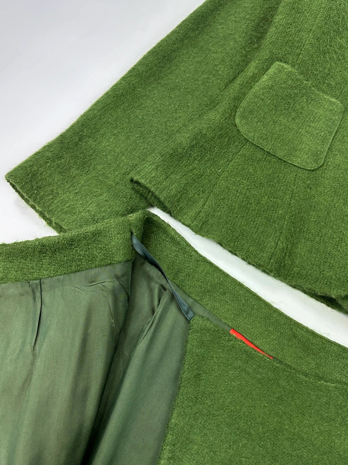 Kenzo green mohair skirt suit set with adjustable wrap skirt and logo detail.