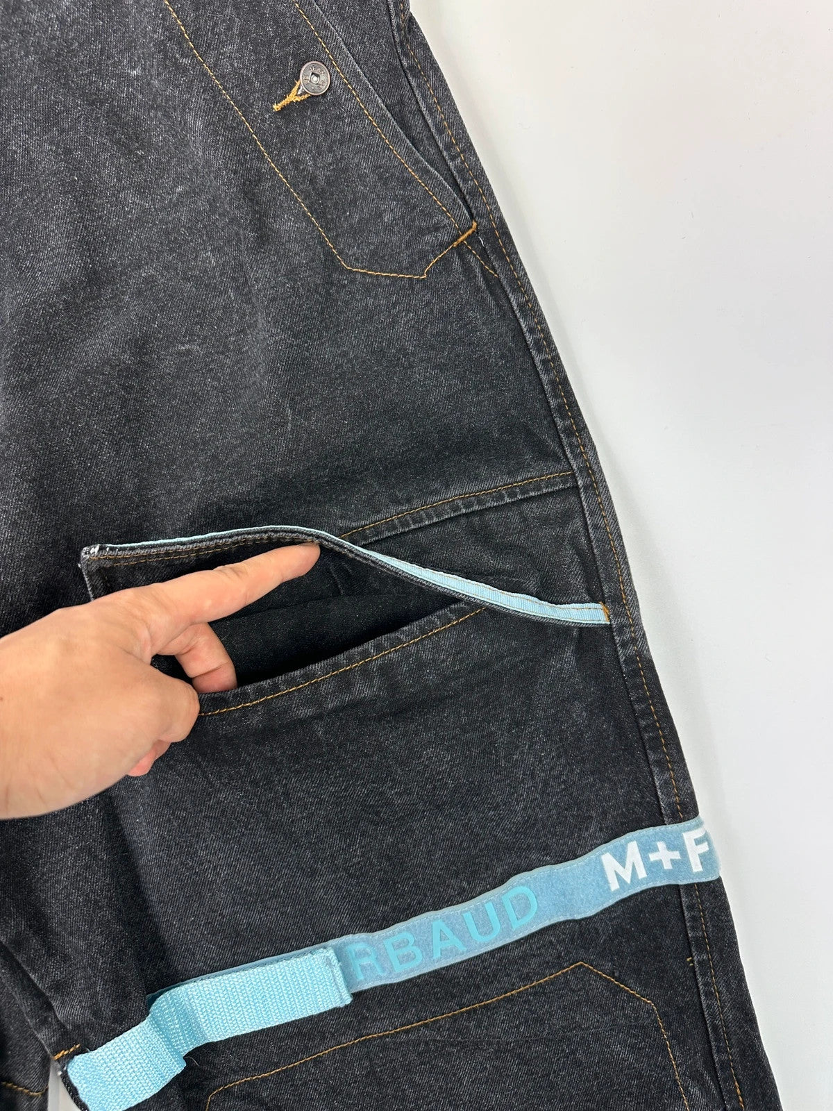 Marithé François Girbaud black and turquoise baggy denim trousers with cargo pockets and velcro details.