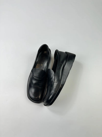 Prada black leather platform loafers with minimalist design and archival style from SS1998.
