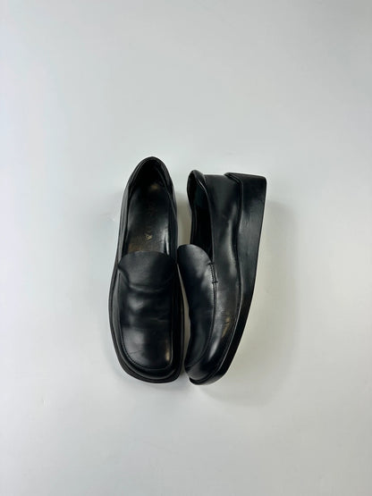 Prada black leather platform loafers with minimalist design and vintage 1998 collection details.