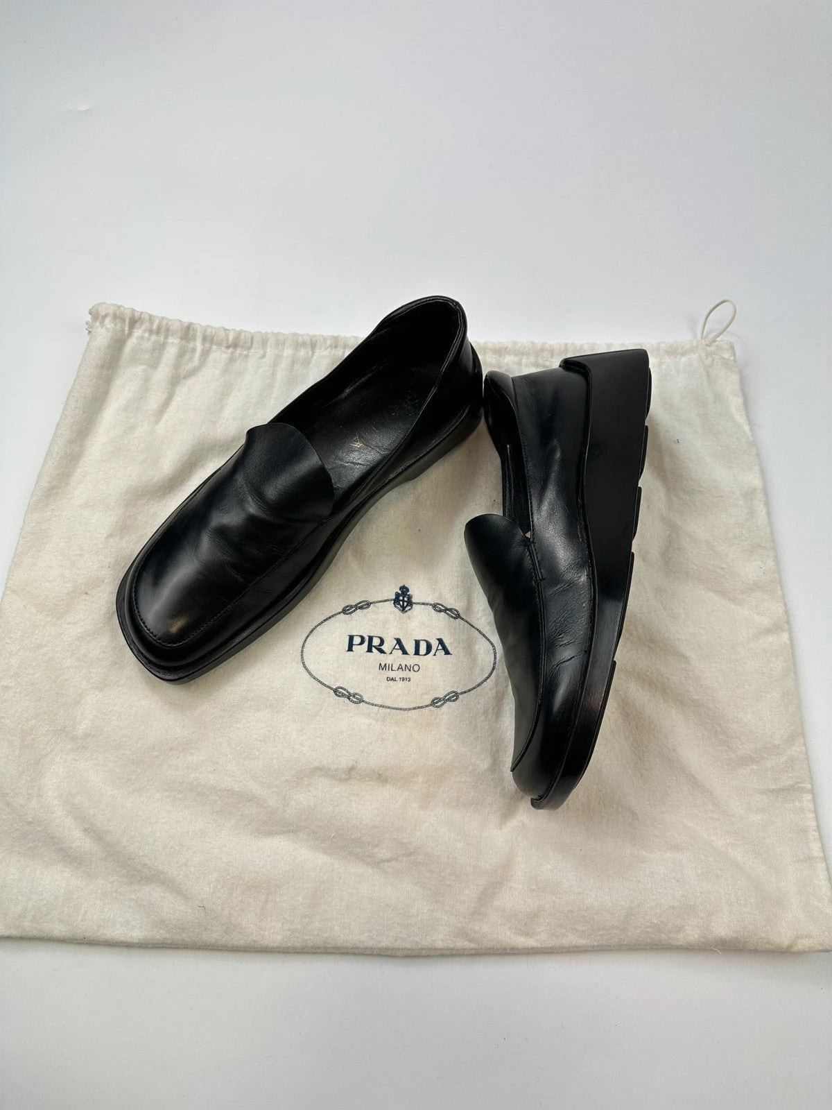 Prada black leather platform loafers with minimalist design and archival style from SS1998.