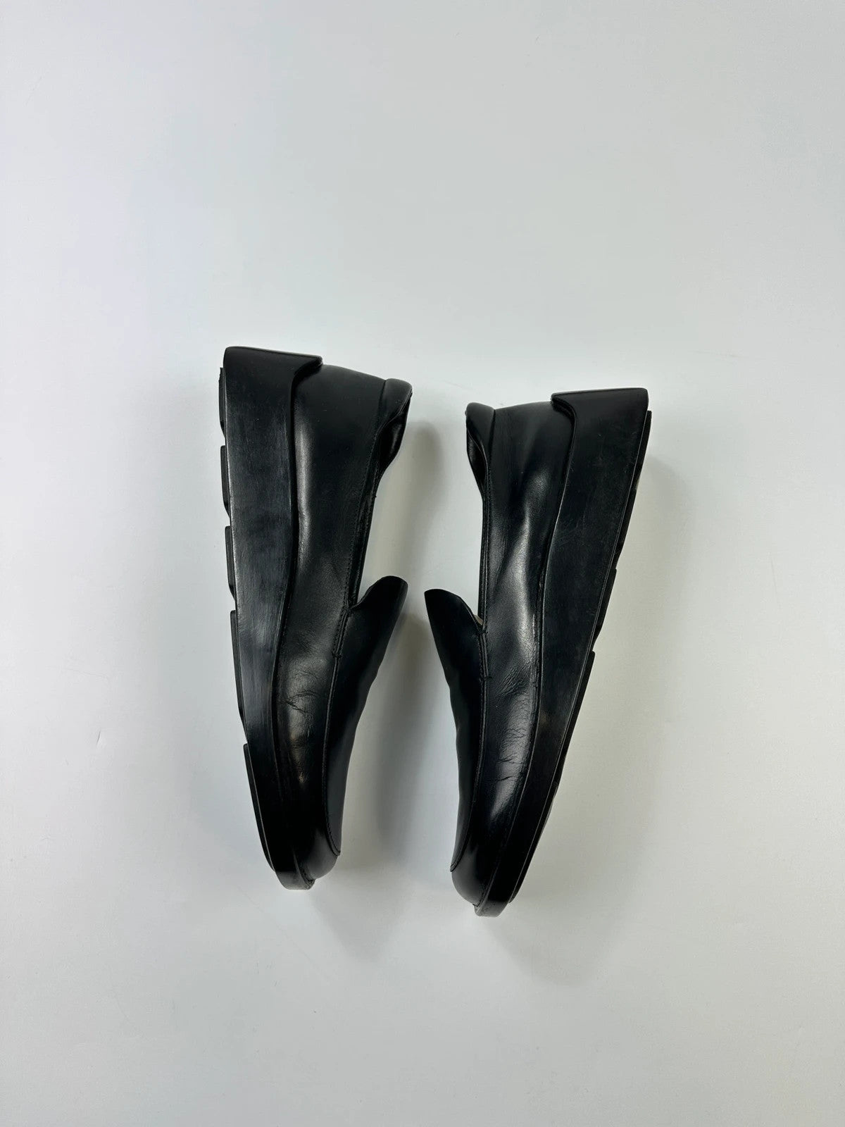 Prada black leather platform loafers with minimalist design and vintage 1998 collection details.