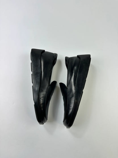 Prada black leather platform loafers with minimalist design and vintage 1998 collection details.