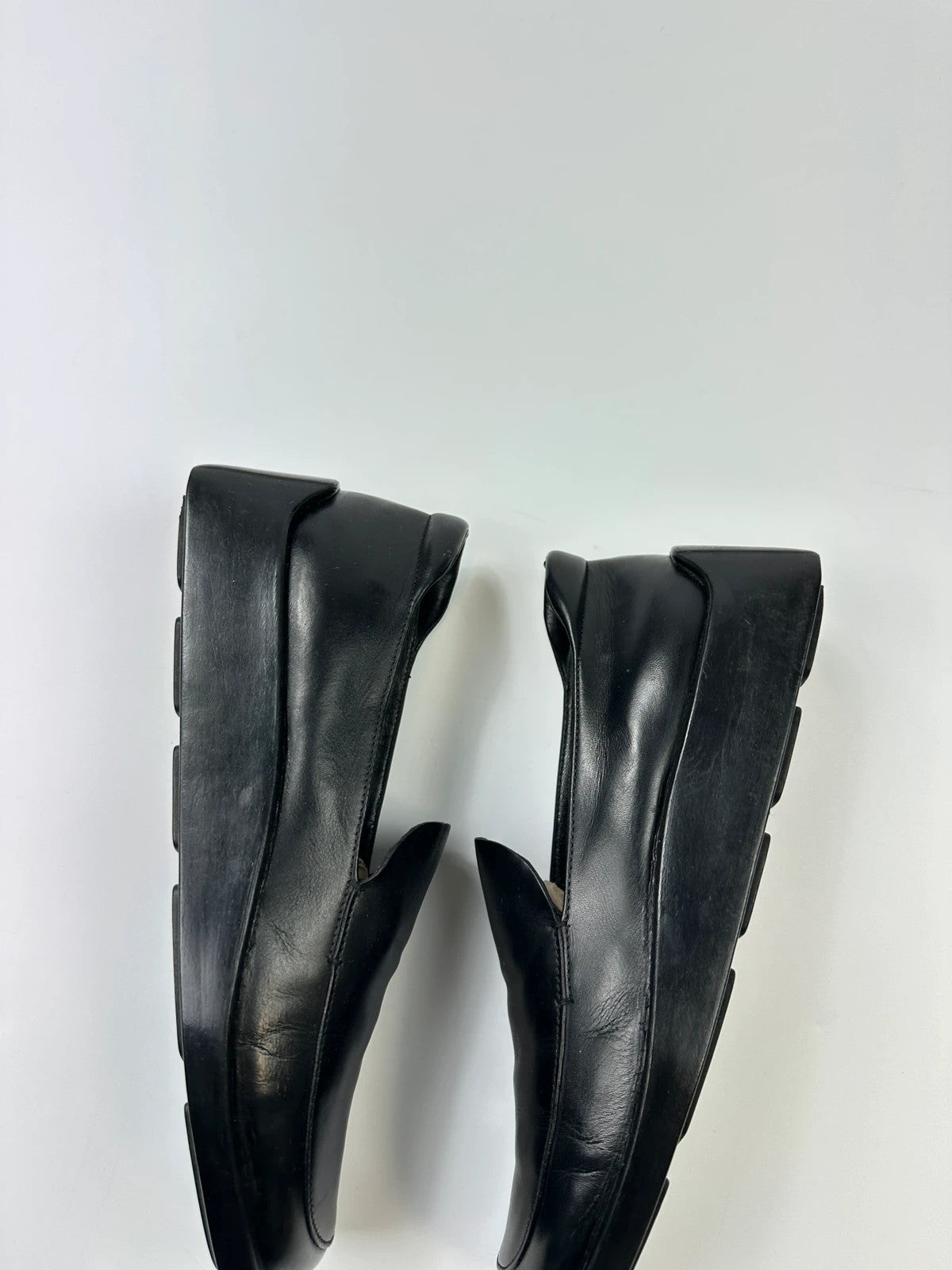 Prada black leather platform loafers with minimalist design and vintage 1998 collection details.