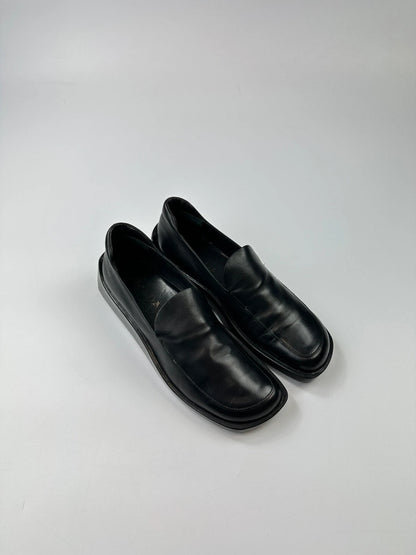 Prada black leather platform loafers with minimalist design and vintage 1998 collection details.