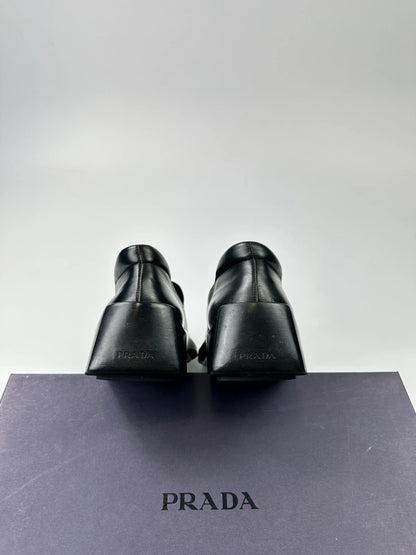 Prada black leather platform loafers with minimalist design and vintage 1998 collection details.