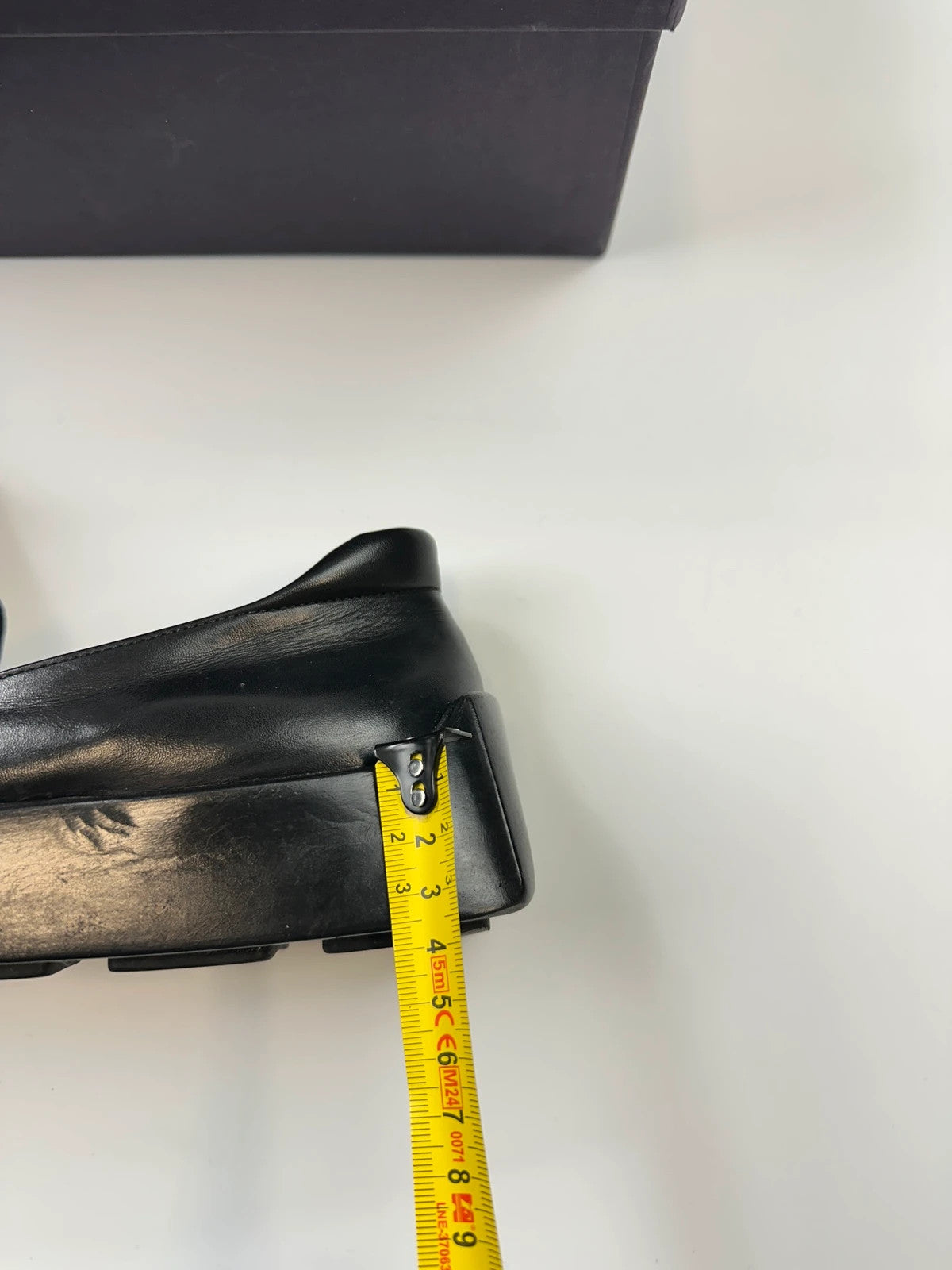 Prada black leather platform loafers with minimalist design and vintage 1998 collection details.