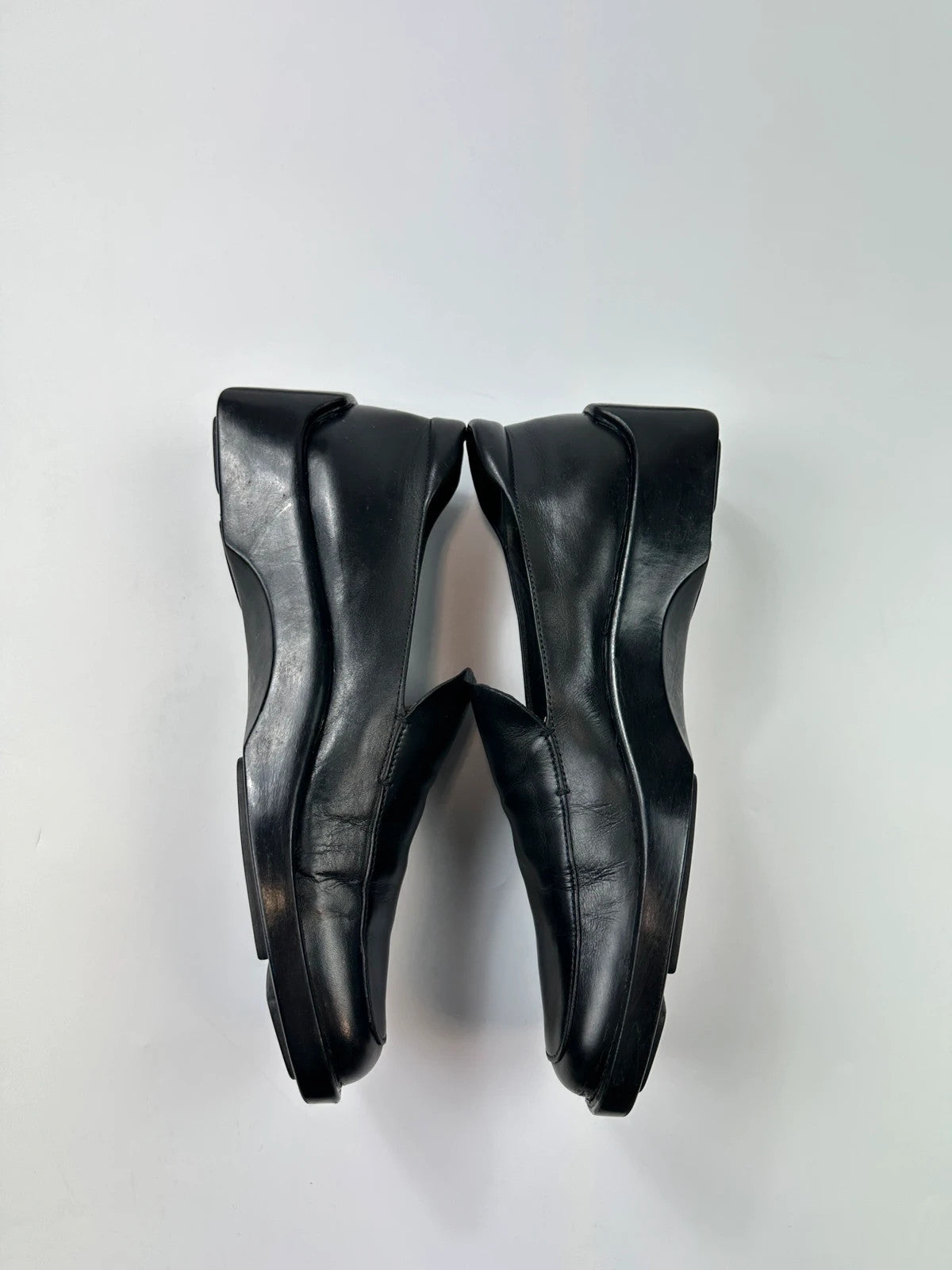 Prada black leather platform loafers with minimalist design and vintage 1998 collection details.