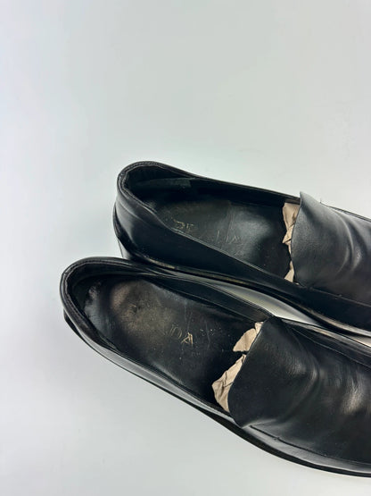 Prada black leather platform loafers with minimalist design and vintage 1998 collection details.
