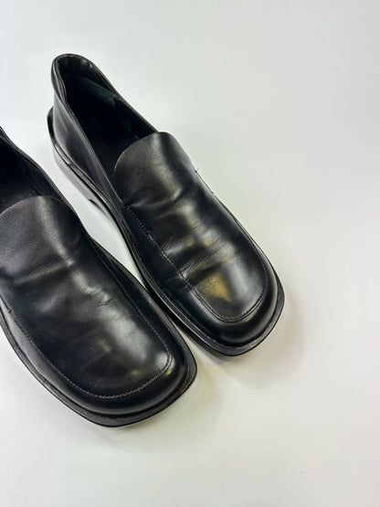 Prada black leather platform loafers with minimalist design and vintage 1998 collection details.