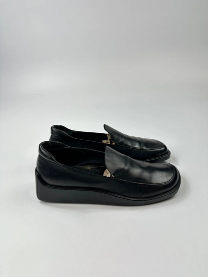 Prada black leather platform loafers with minimalist design and vintage 1998 collection details.