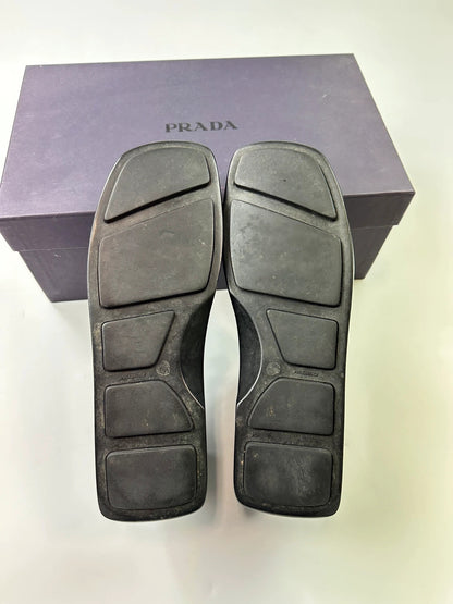 Prada black leather platform loafers with minimalist design and vintage 1998 collection details.