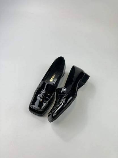 Jil Sander black patent leather loafers with shiny finish and minimalist design.
