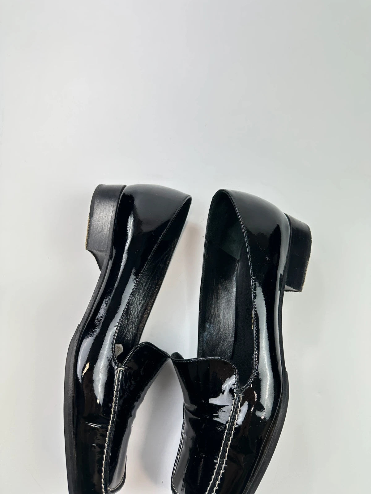 Jil Sander black patent leather loafers with shiny finish and minimalist design.