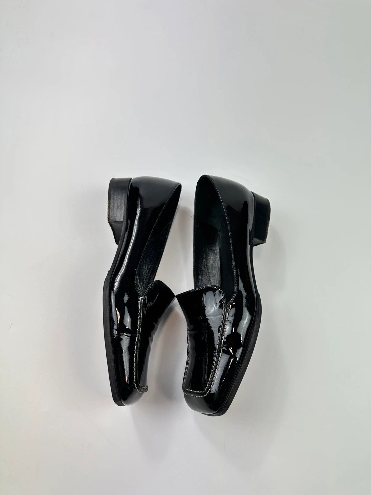 Jil Sander black patent leather loafers with shiny finish and minimalist design.