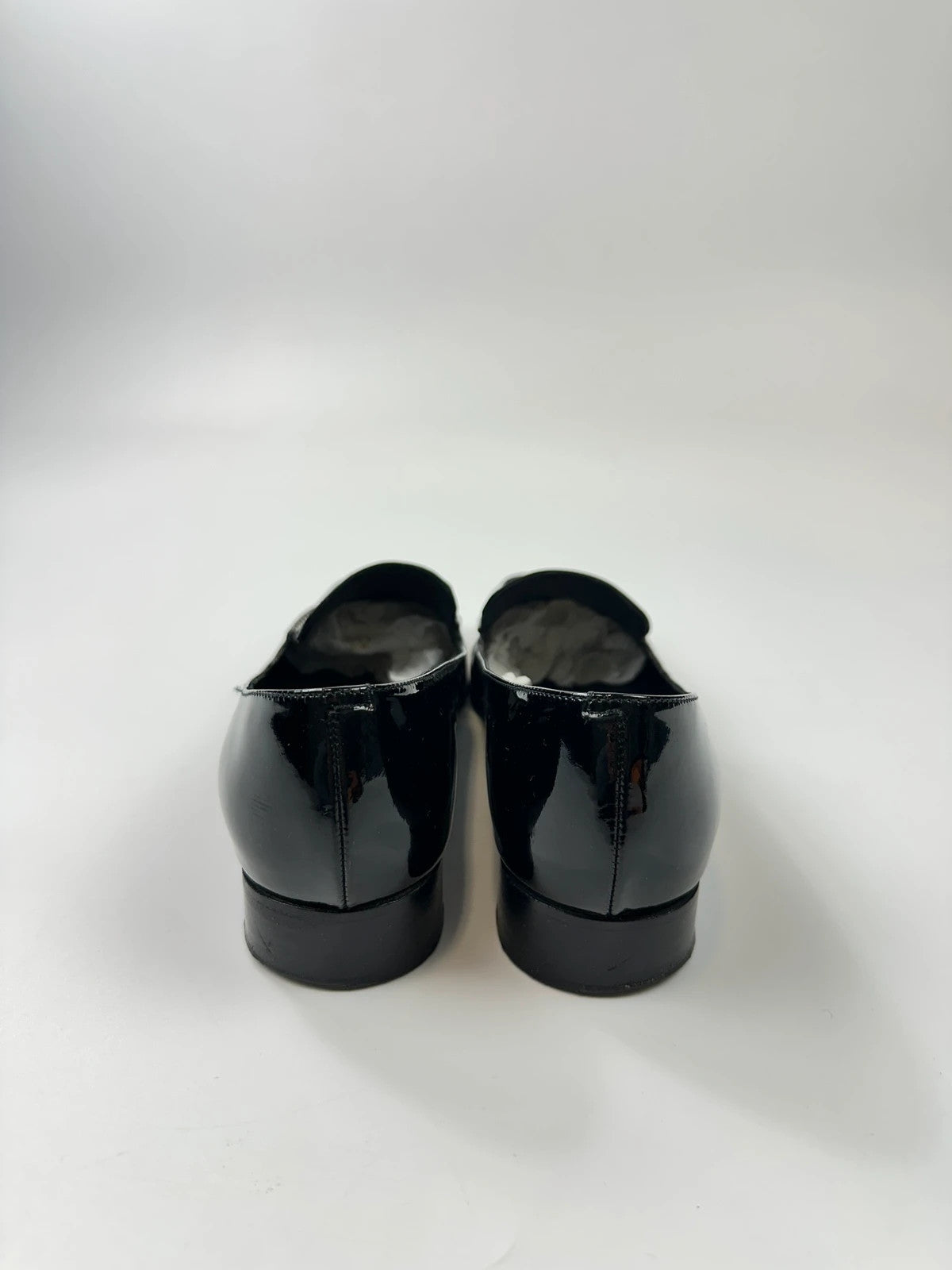 Jil Sander black patent leather loafers with shiny finish and minimalist design.