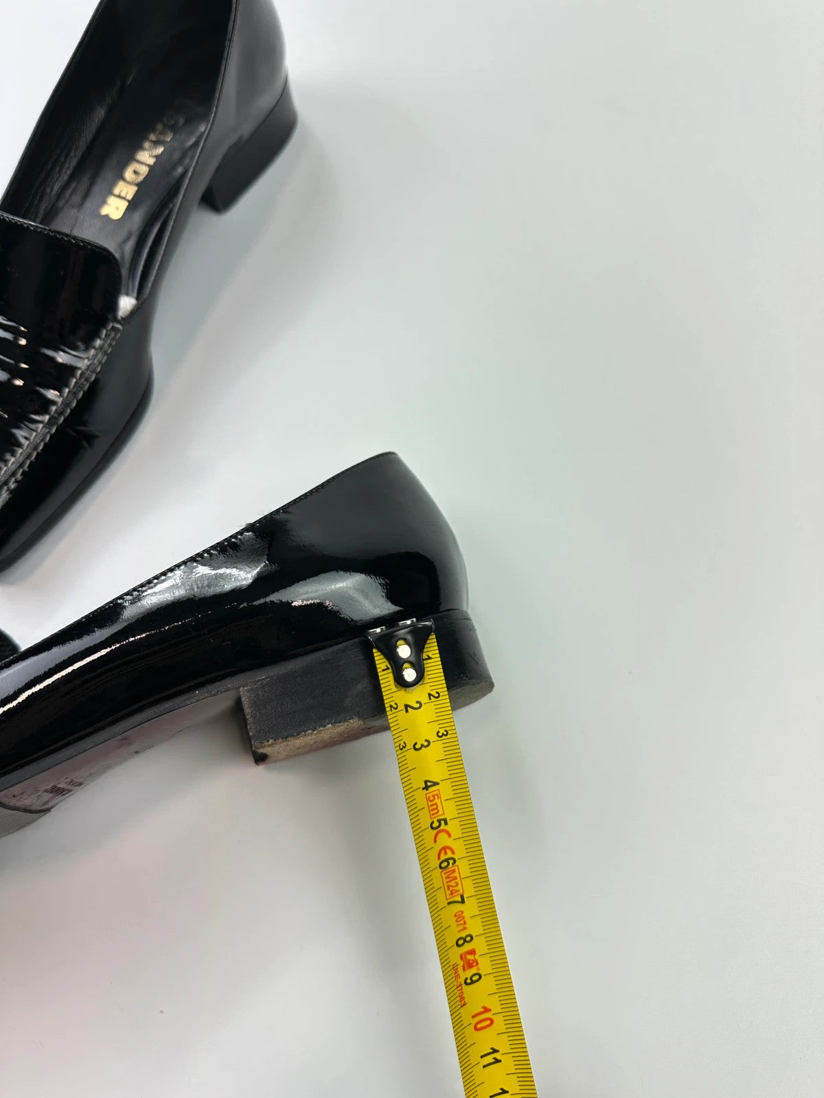 Jil Sander black patent leather loafers with shiny finish and minimalist design.