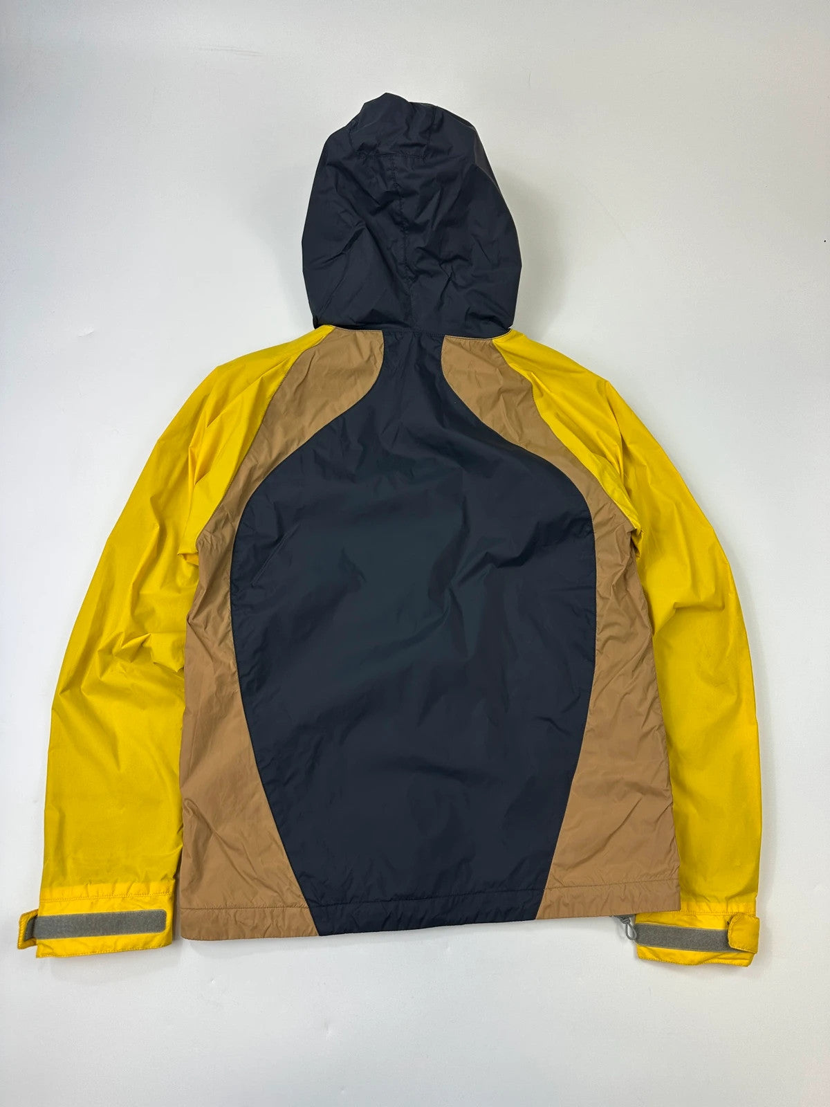 Comme Des Garçons navy and yellow block nylon hooded jacket with logo detail.