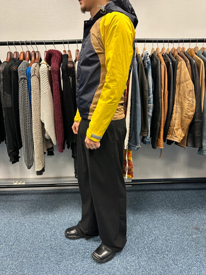 Comme Des Garçons navy and yellow block nylon hooded jacket with logo detail.