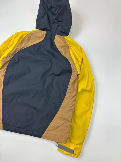 Comme Des Garçons navy and yellow block nylon hooded jacket with logo detail.