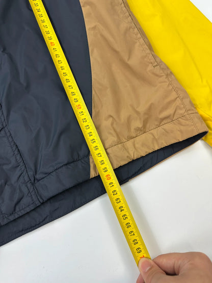 Comme Des Garçons navy and yellow block nylon hooded jacket with logo detail.