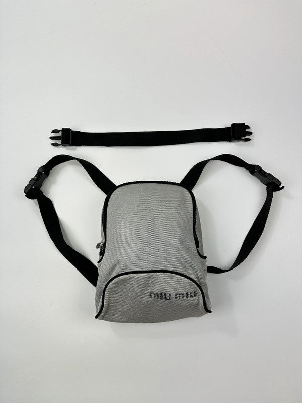 Miu Miu grey mesh 2-in-1 chest bag backpack with faded logo and minimalist design.