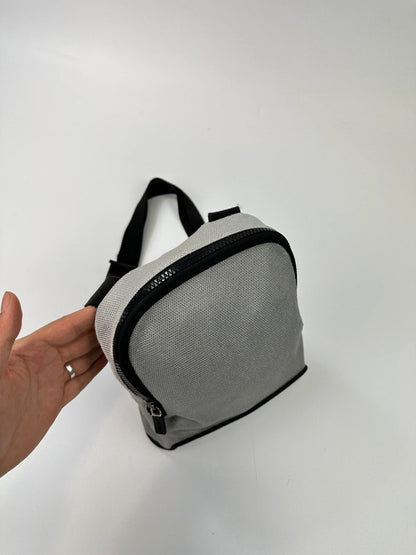 Miu Miu grey mesh 2-in-1 chest bag backpack with faded logo and minimalist design.