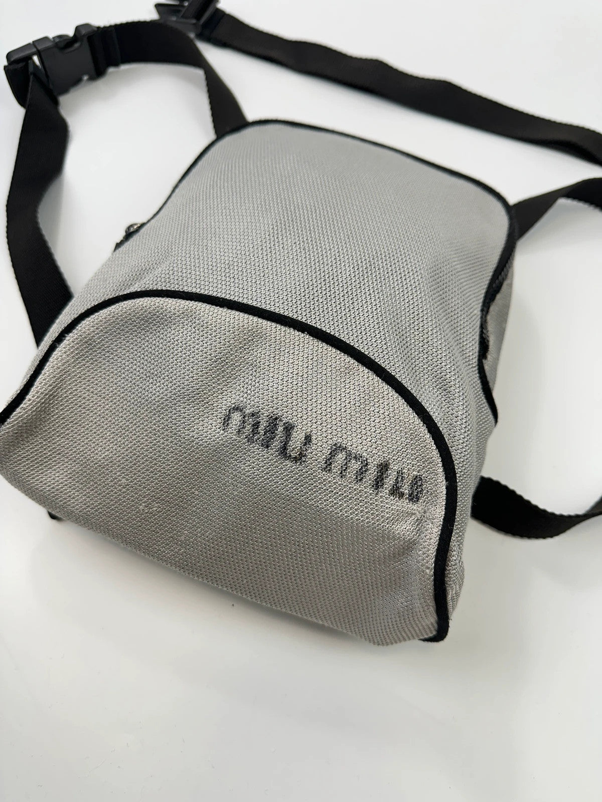 Miu Miu grey mesh 2in1 chest bag backpack, faded logo, minimalist design.