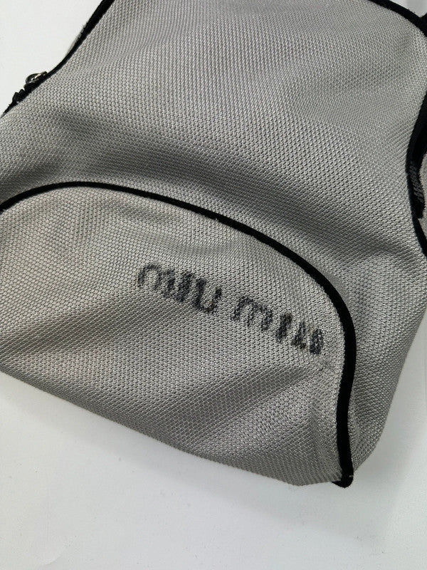 Miu Miu grey mesh 2-in-1 chest bag backpack with faded logo and minimalist design.