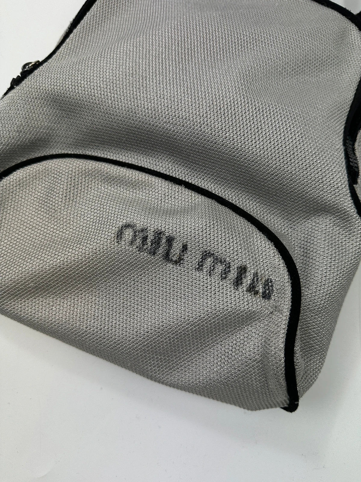 Miu Miu grey mesh 2in1 chest bag backpack, faded logo, minimalist design.