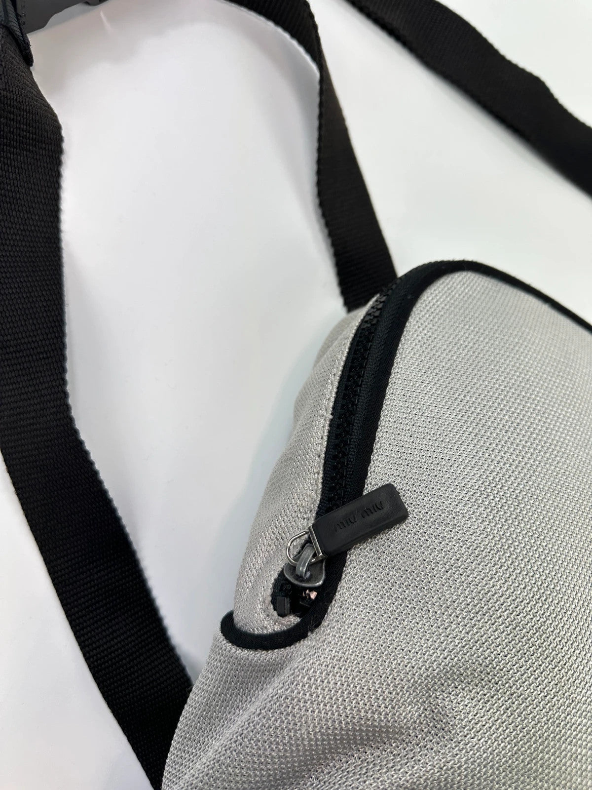 Miu Miu grey mesh 2in1 chest bag backpack, faded logo, minimalist design.