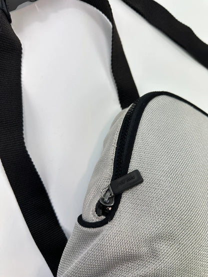 Miu Miu grey mesh 2in1 chest bag backpack, faded logo, minimalist design.