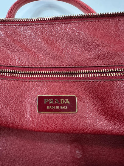 Prada red leather handbag with gold hardware and vintage logo detail.